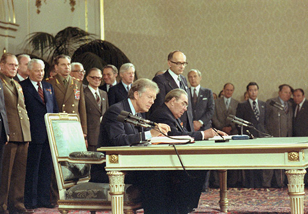 Jimmy Carter and Leonid Brezhnev are seated as they sign the SALT II treaty.