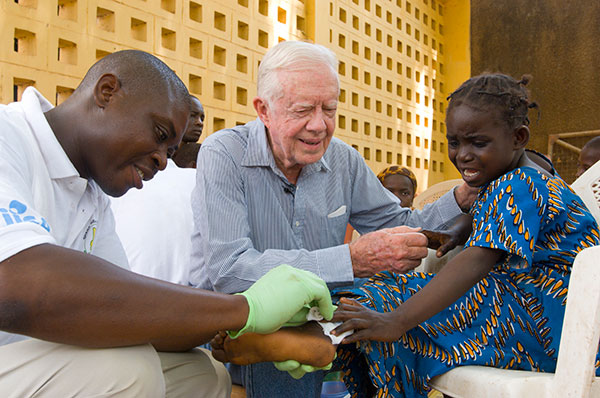 Jimmy Carter consoles a young Ghanaian girl.