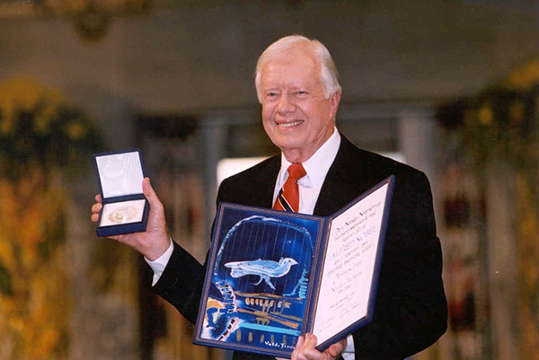 Jimmy Carter holding his Nobel medal and diploma.