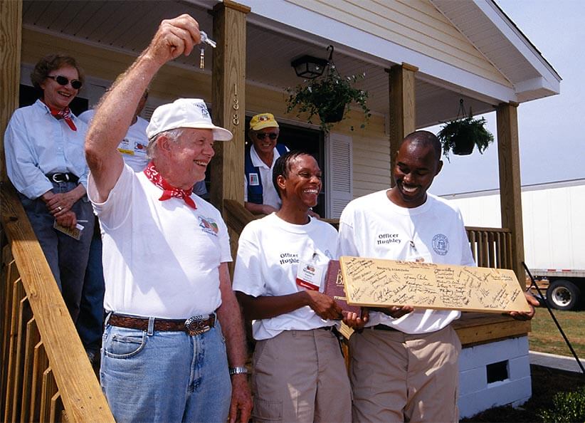 Jimmy Carter hands Neal and Michele Hughley a set of keys.