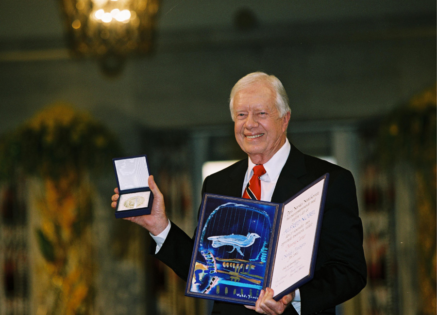 Jimmy Carter shows his Nobel medal and diploma in 2002.