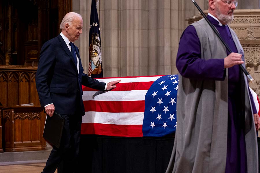 President Biden touches President Carter’s casket.